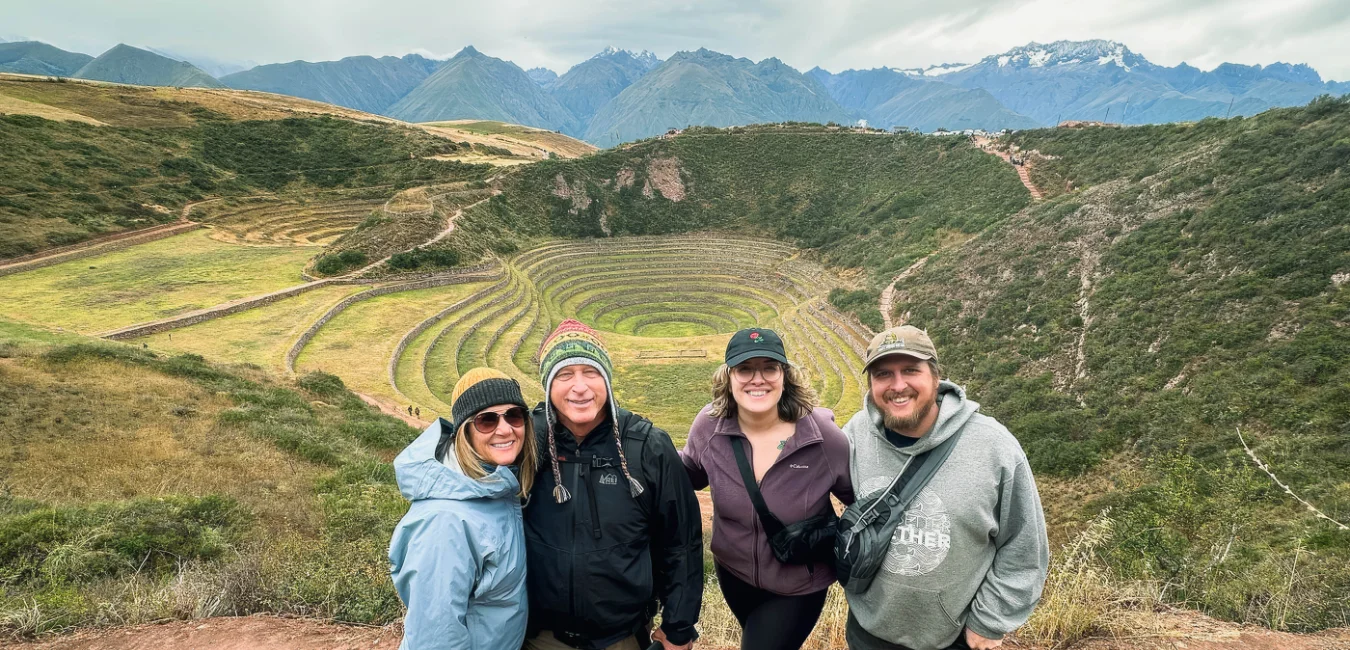 Group of tourists posing at the circular terraces of Moray