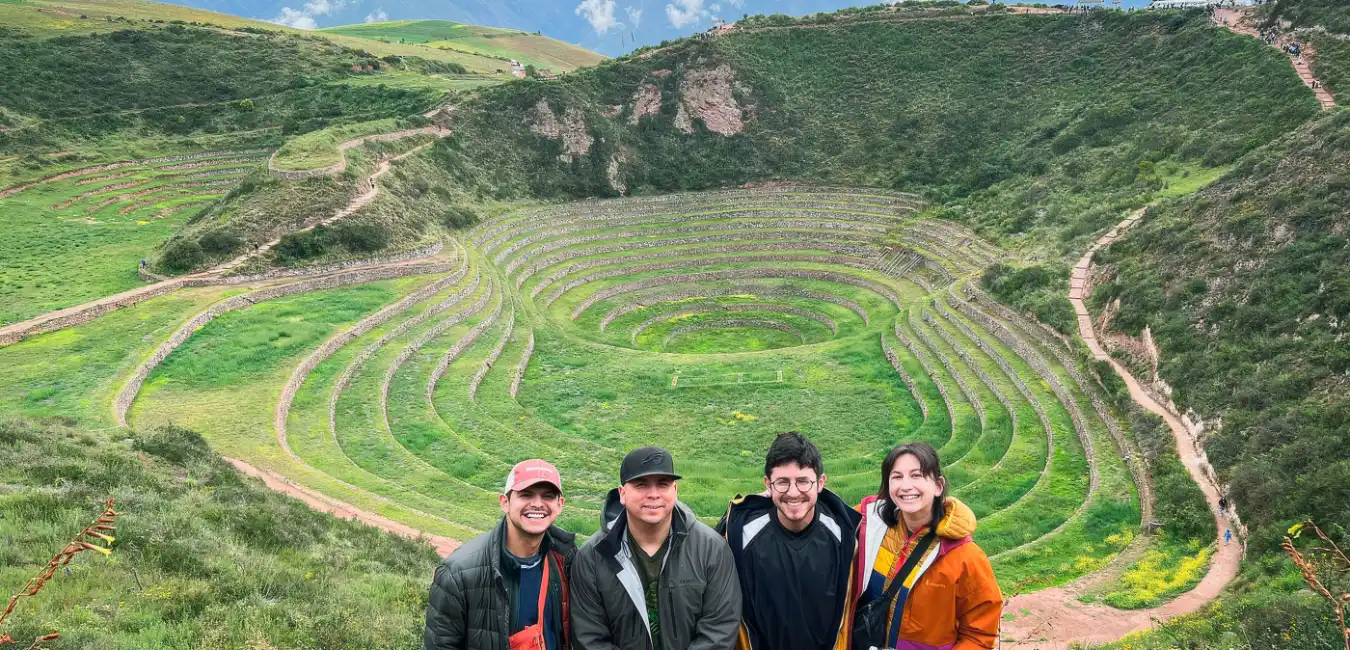 Private tour group posing at Moray Inca agricultural terraces in Peru