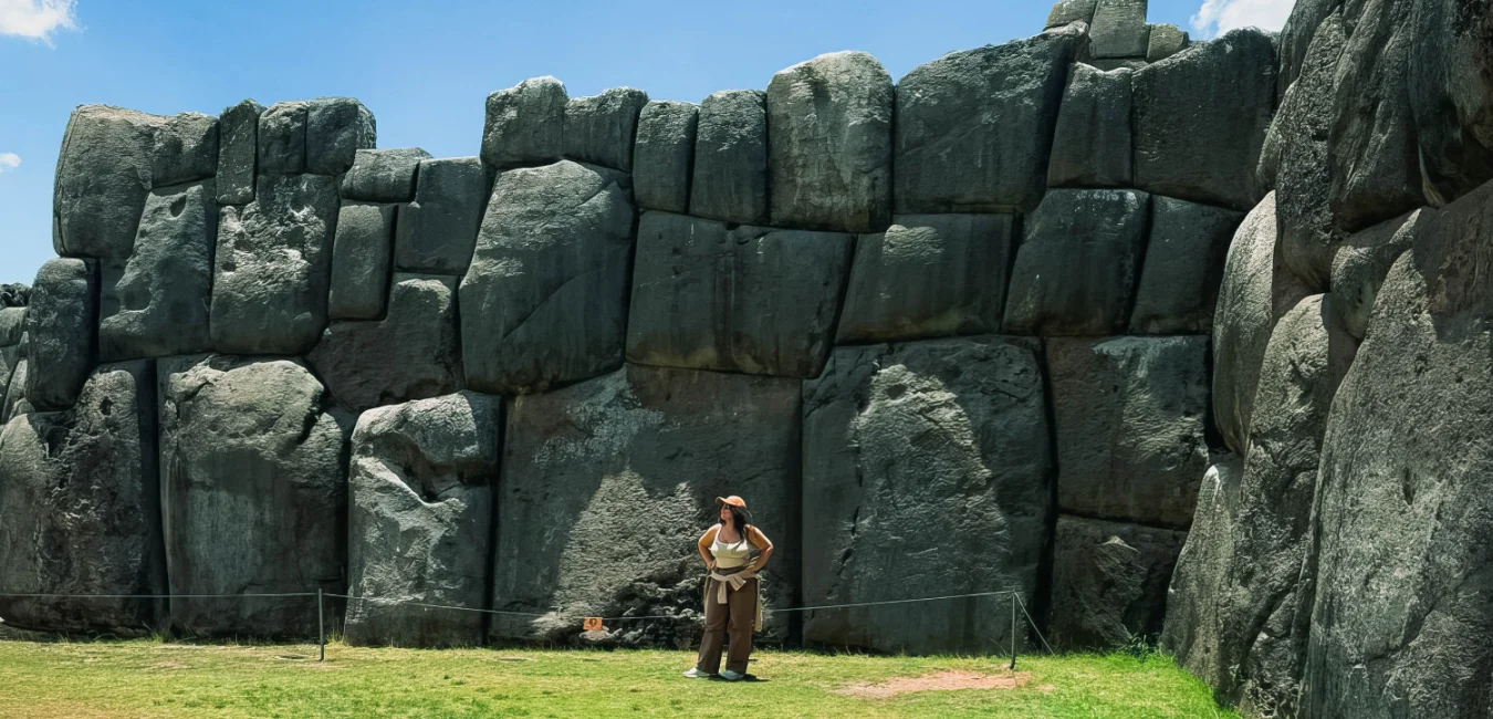 Tourist standing by the massive stone walls of Sacsayhuaman fortress in Cusco