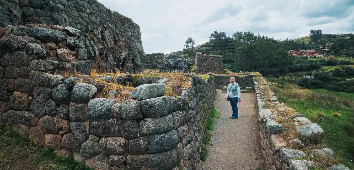 Visitor walking through the Puka Pukara Inca ruins during a half day Cusco tour